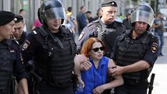 Agentes de la polica rusa conducen a una de las mujeres detenidas en el centro de Mosc