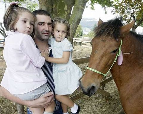 Un pap, descubriendo a sus hijas los caballos de As San Lucas. 