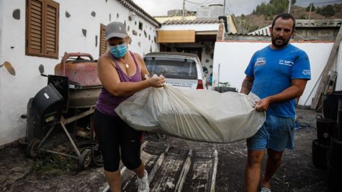 Un hombre y una mujer sacan sus pertenencias en Tajuya, una de los barrios desalojados el viernes tras el repunte de la actividad volcnica