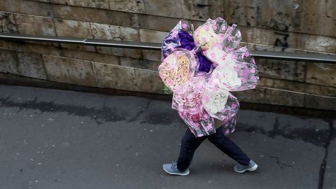 Un hombre intenta vender ramos de flores en Kiev. 