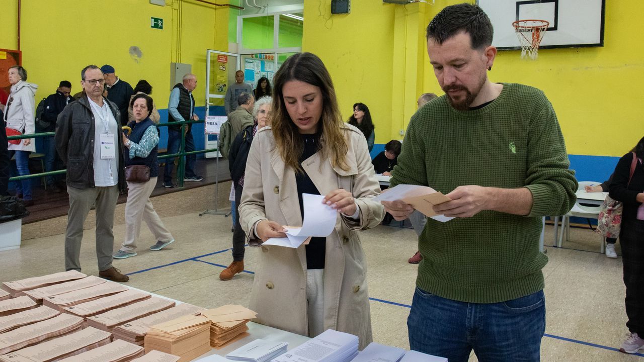 La ministra de Igualdad, Irene Montero, y el exvicepresidente Pablo Iglesias, este domingo, escogiendo las papeletas en el centro de votacin