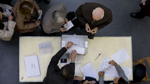 Ciudadanos hacen cola para depositar su voto en un colegio electoral de Barcelona