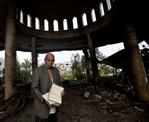 Un palestino recupera la copia de un Corn en la mezquita bombardeada ayer en Gaza. 