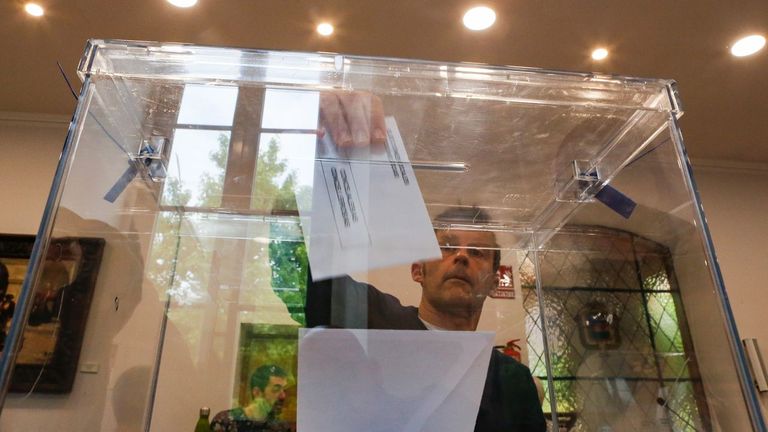 Un vecino de Noia depositando la papeleta en una urna