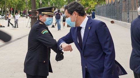 El presidente de la Junta, Juanma Moreno saluda a un miembro de la policia nacional en un acto de homenaje a las víctimas