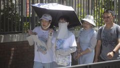 Turistas japoneses se protegen del calor en Madrid