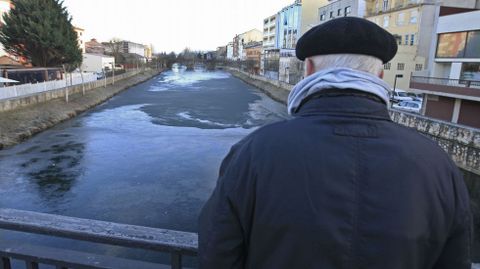 Un hombre mira desde el puente nuevo de Monforte el ro Cabe congelado 