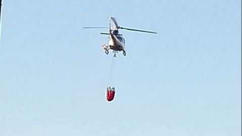 Una fotografa tomada por un vecino de Rosende, en Sober, muestra un helicptero acercndose a la laguna artificial de esta localidad para atacar el incendio de Pantn