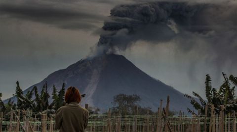 Una mujer observa como el volcn del Monte Sinabung arroja al aire cenizas volcnicas en Karo (Indonesia)