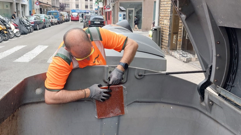 Operario de Emulsa (Gij�n) coloca una placa antiolor en un contenedor