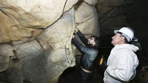 El conselleiro de Cultura, Román Rodríguez ?a la derecha?, observa las muestras de arte rupestre de Cova Eirós en una visita que realizó a la cueva de Triacastela en el 2018