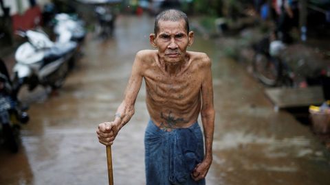 Un ancano camina por una calle inundada de Kayin, en Birmania