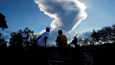La gente mira como el volcn Monte Merapi entra en erupcin, en Indonesia