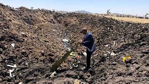 Un hombre inspecciones el lugar del accidente, en Bishoftu, 60 kilómetros al sureste de Addis Abeba, Etiopía