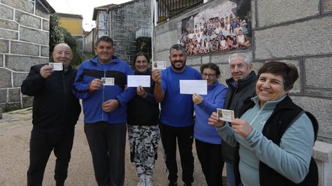 Vecinos de A VIla (Lobios) posan con el décimo de la Lotería de Navidad que les regaló anónimamente un misterioso vecino.