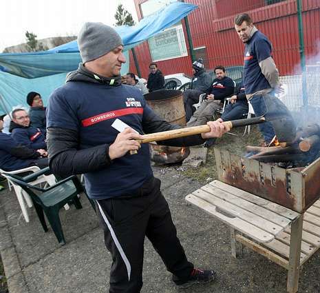 Un bombero prepara la parrilla para la churrascada.