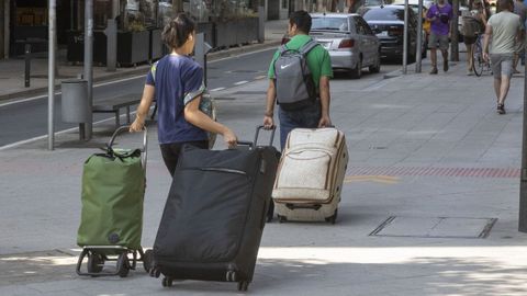 Turistas con maletas por el ensanche compostelano (foto de archivo)