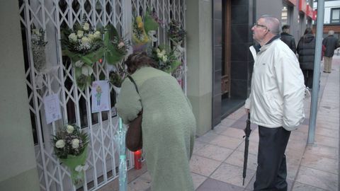 Vecinos ante la tienda de Cristina Cabo, llena de flores y dibujos