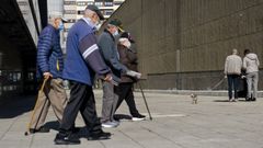 Varias personas mayores paseando por una ciudad gallega