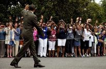 Obama saluda a un grupo de seguidores que lo jalean en los jardines de la Casa Blanca.