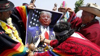 Un grupo de Chamanes aguantan un pster de Donald Trump como parte de un ritual para las predicciones del nuevo ao (Lima, Per)