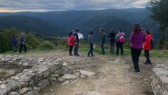Un grupo de turistas visitando el castro de Arxeriz, en el municipio de  O Saviao
