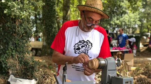 Un artesano trabaja la madera durante la Muestra de Artesanía, en la XXX Romaría Labrega da Chaira (Guitiriz).