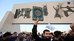 Protestante iraquí levanta una copia del Corán en una manifestación en Bagdad