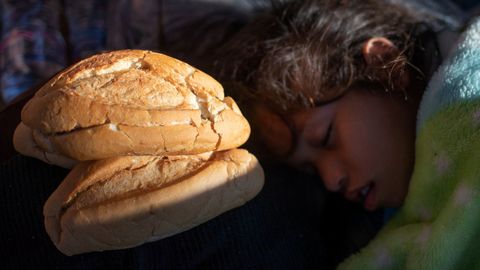 Una de las nias que forma parte de la caravana de migrantes de Centroamrica que parten hacia Estados Unidos, duerme cerca de dos pedazos de pan 
