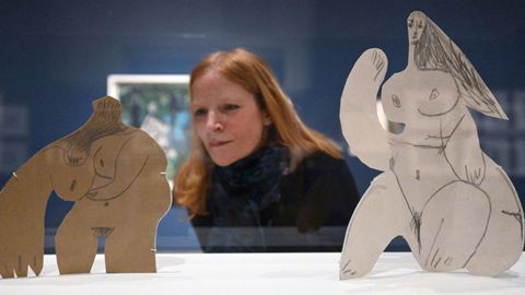 Una visitante observa dos desnudos femeninos realizados por Picasso en cartn dibujado