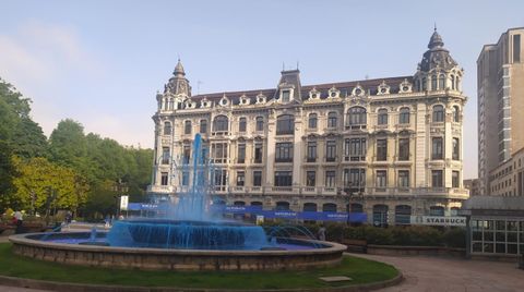 La fuente de la Plaza de la Escandalera, en Oviedo, teida de azul