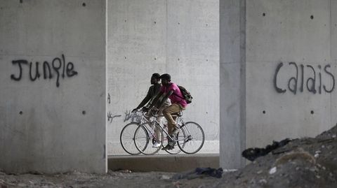 Dos ciclistas pasean en Calais, la Nueva Jungla de los inmigrantes
