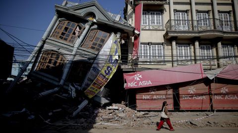  Una mujer pasea frente a un edificio destrozado tras el sesmo que desvast Nepal el pasado 25 de abril, en Balaju, Katmand.