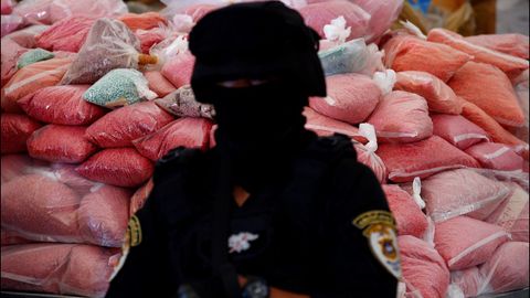 Un policía tailandés vigila un varias bolsas con narcóticos antes de proceder a la destrucción de 9.322 kilos de drogas ilegales en la ciudad de Bang Pa-in (Tailandia). 