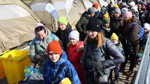 Refugiados ucranianos cerca de unas tiendas después de cruzar la frontera entre Ucrania y Polonia