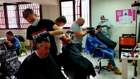 Alumnos de la escuela de barbera de la peluquera Paulino realizando sus prcticas en el Albergue Covadonga