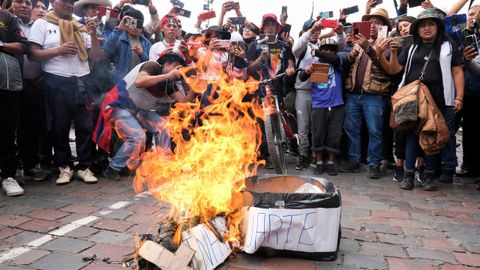 Varios manifestantes fotografían en Cusco la quema de un ataúd simulado de Dina Boluarte, la nueva presidenta de Perú.