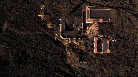 17 de diciembre. Vista aérea de una casa rodeada por la lava del volcán Cumbre Vieja en una zona de exclusión en Las Manchas