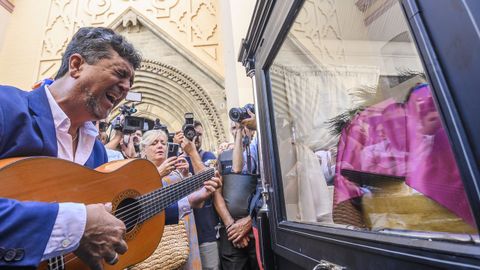 Un guitarrista frente al féretro a la salida de la iglesia de Santa Ana de Triana
