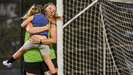 Una madre celebrando con su hija en un campo de f�tbol.