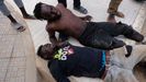Dos migrantes después de saltar la valla de Melilla 