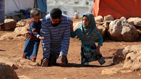 Una nia siria camina con unas prtesis hechas con latas por su padre