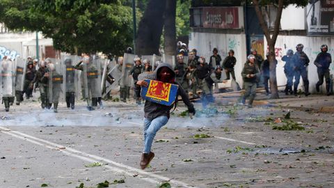 Una manifestante huye durante una protesta antigubernamental en Caracas