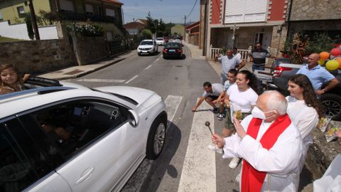 Imagen de la celebración del San Cristóbal en Abanqueiro el pasado año, con el párroco bendiciendo los vehículos.