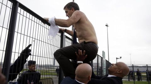 Xavier Broseta, sin camisa, intenta saltar una valla para huir del lugar