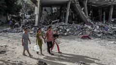Unos nios palestinos caminan entre edificios destruidos en Rafah