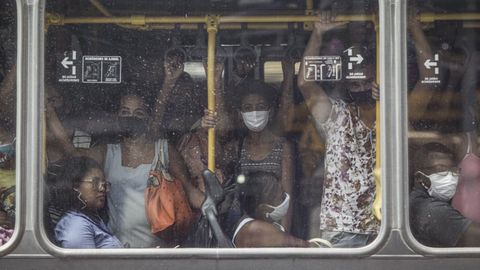 Brasileos incumpliendo la distancia de seguridada dentro de un autobs en Ro de Janeiro