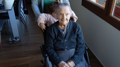 Luisa, con la pequeña Xiana subida en la parte de atrás de su silla de ruedas, en su casa, hace unas semanas