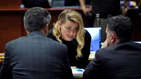 Amber Heard habla con sus abogados en el juzgado