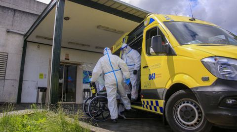 Tcnicos de ambulancia con trajes anticontagio en la puerta de urgencias del hgospital de Monforte